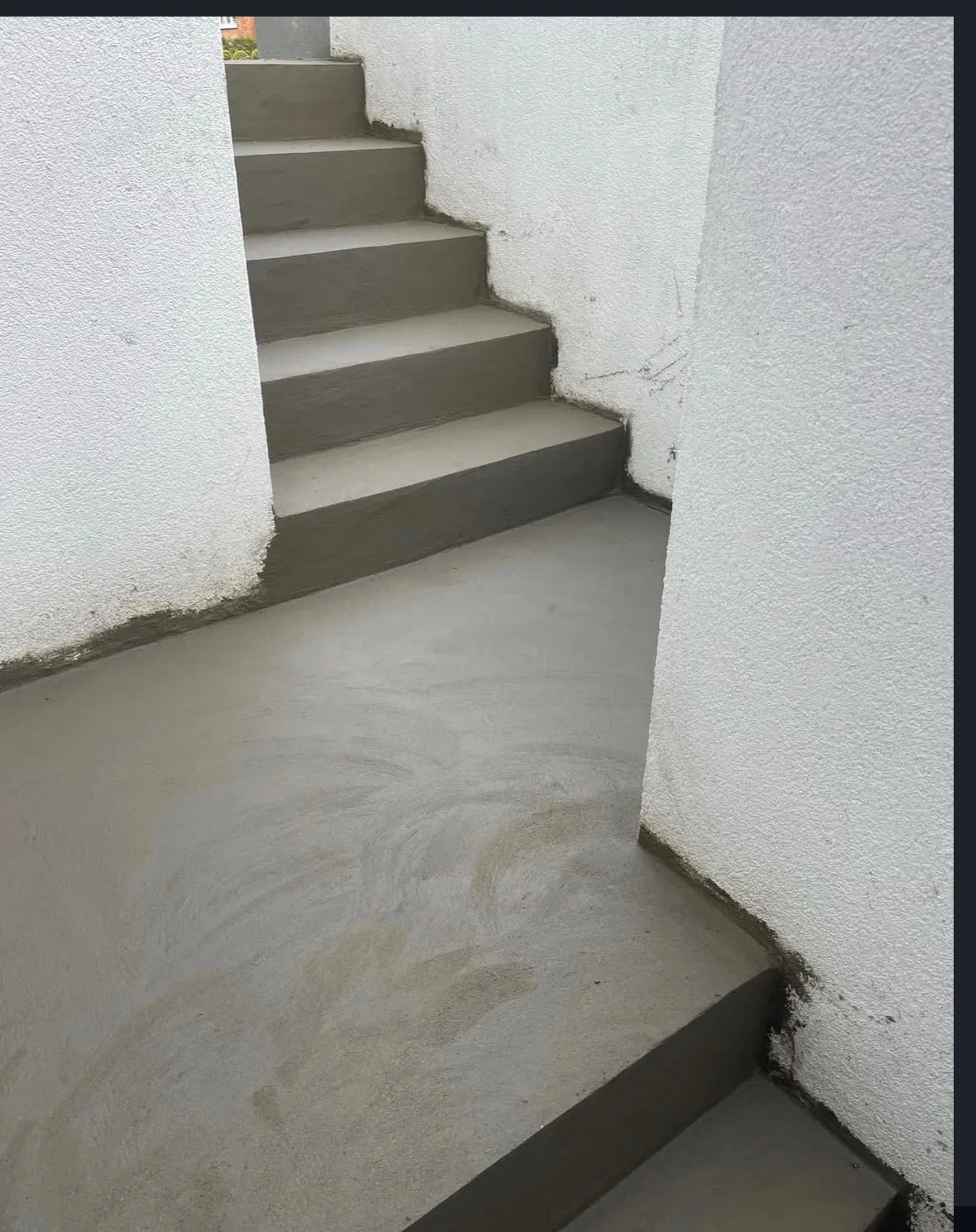 Betontrappe og repos mellem hvide vægge.